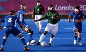 Players participating in a competitive blind football match using sound cues and teamwork.
